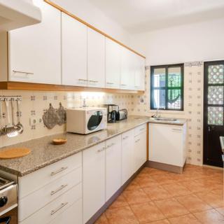 Algar Seco Parque | Carvoeiro, Algarve | kitchen with white finishing's and brown tile floors