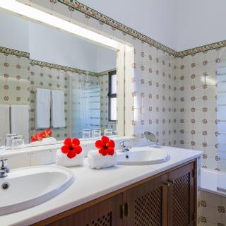 Algar Seco Parque | Carvoeiro, Algarve | white villa 5 bathroom with red hibiscus flowers on sink and hand painted tiles