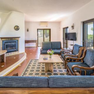 Algar Seco Parque | Carvoeiro, Algarve | V4 villa living room with two sofas and two chairs and fireplace